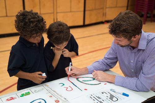 Students watch a teacher drawing